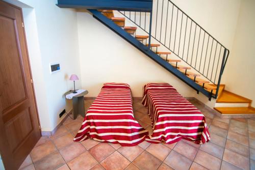 two beds sitting on the floor under a staircase at Agriturismo Turina in Bricherasio