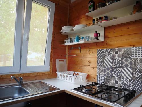 a kitchen with a stove and a sink at Camping Fiori di Noto in Noto