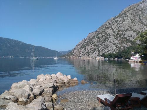a view of a body of water with rocks and a boat at Apartments Nadja in Kotor