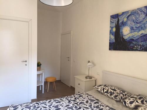 佛羅倫斯的住宿－La casetta dipinta，卧室配有一张床,墙上挂有绘画作品