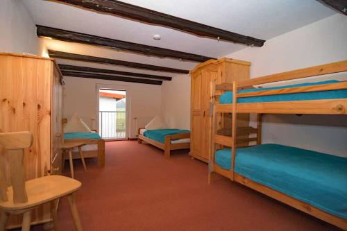 a room with three bunk beds and a table at Pferdehof Berger in Penig