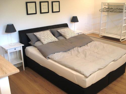 ein großes Bett in einem Schlafzimmer mit zwei Nachttischen in der Unterkunft Ferienwohnung am Schöhsee in Plön