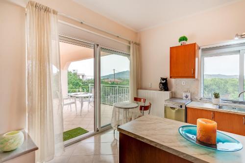 a kitchen with a view of a balcony at Villa Rosemagnolia, pool 35m2, in green, gardens, full sun close to everything in Ayiá