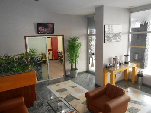 a living room with a chair and a table and a mirror at Hotel Del Centro in Guayaquil