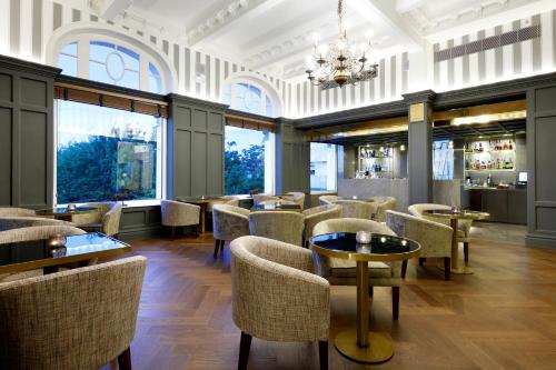 a restaurant with chairs and tables and windows at Eurostars Hotel Real in Santander