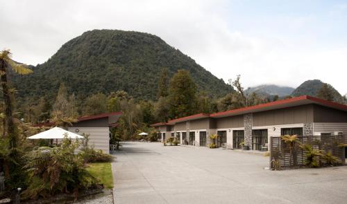 a building with a mountain in the background at 58 On Cron Motel in Franz Josef