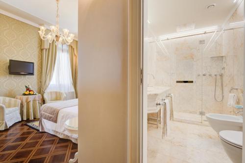 a bathroom with a bed and a tub and a sink at Hotel Al Duca Di Venezia in Venice