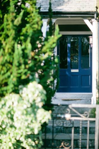 a blue door on a house with a fence at Rum Doodle, Windermere B&B in Windermere