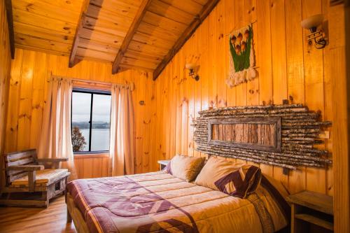 a bedroom with a bed in a wooden room at Apart hotel Puchaley Lafquen in Panguipulli