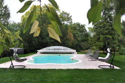 - une piscine entourée de chaises dans une cour dans l'établissement Le Manoir De Bonal, à Penne-dʼAgenais