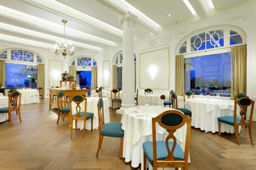 a dining room with tables and chairs and windows at Eurostars Hotel Real in Santander