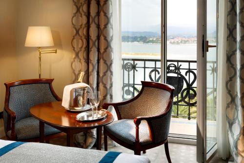 a hotel room with a table and chairs and a balcony at Eurostars Hotel Real in Santander