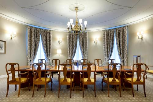a dining room with a table and chairs and a chandelier at Eurostars Hotel Real in Santander