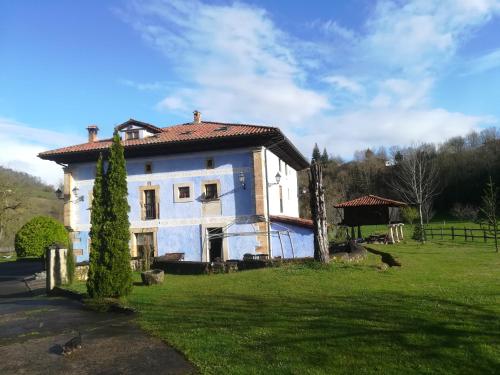 an old house in a field with birds in front of it at Hotel Rural Sucuevas in Mestas de Con