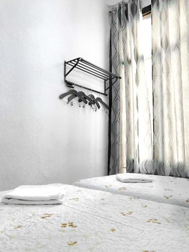 a bedroom with a white bed with a window at Hostal Los Arcos in Madrid