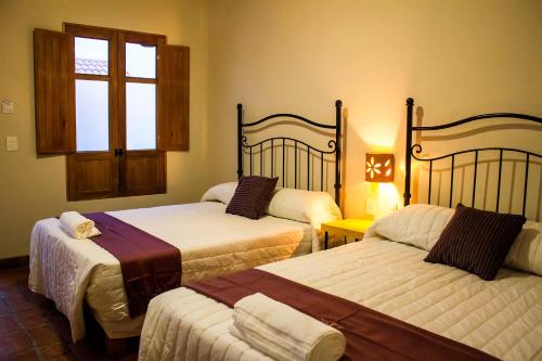 a bedroom with three beds and a window at Puerta San Pedro in Guadalajara