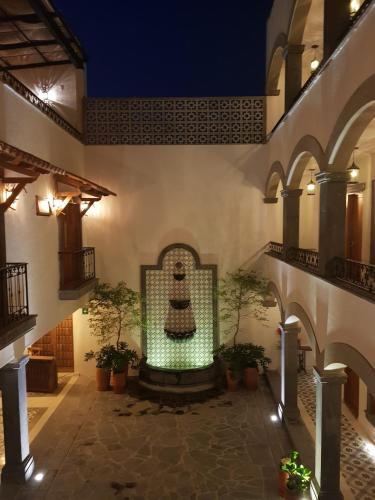 a courtyard with a fountain in a building with potted plants at Puerta San Pedro in Guadalajara