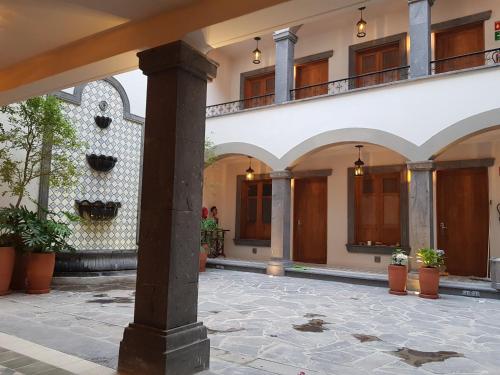 a courtyard of a building with a column and potted plants at Puerta San Pedro in Guadalajara