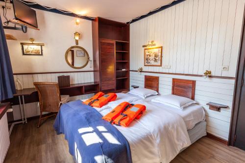
a bedroom with a bed and a dresser at Boat Hotel De Barge in Bruges
