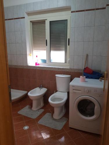 een badkamer met een toilet en een wasmachine bij Apartament Joni in Golem