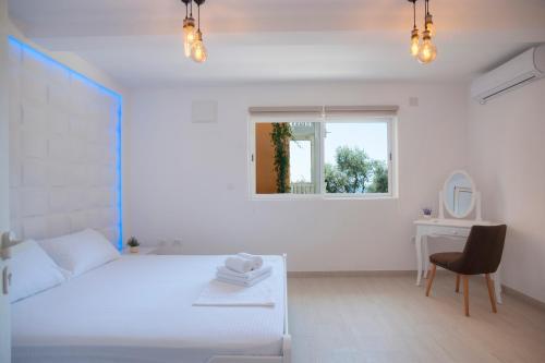 una camera bianca con letto bianco e scrivania di Apartments Dzaleta a Sveti Stefan
