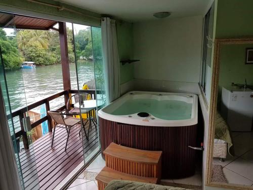 a bath tub in a room with a view of the water at Pousada Miami in Rio de Janeiro