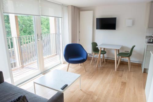 a living room with a couch and a table with chairs at West Court- Jesus College in Cambridge