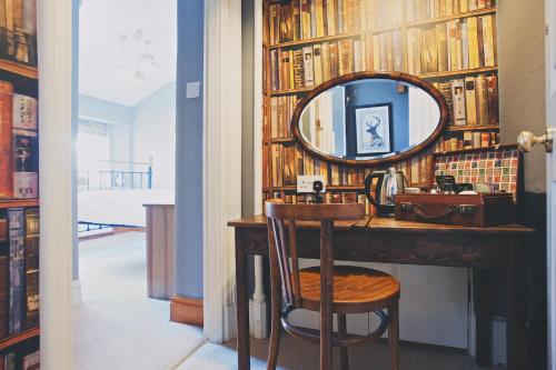 a dressing room with a mirror and a vanity with a chair at Rum Doodle, Windermere B&B in Windermere