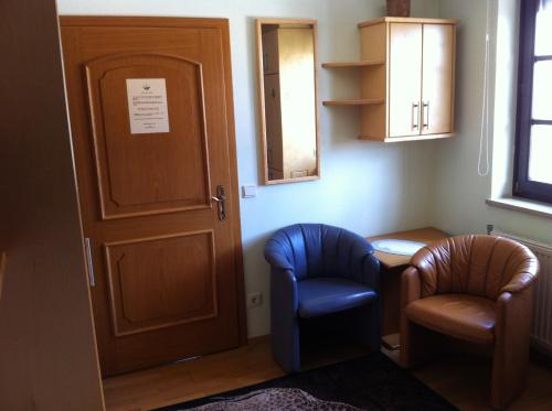 um quarto com duas cadeiras, uma mesa e uma porta em Gästehaus AIGMÜLLER em Bad Schallerbach