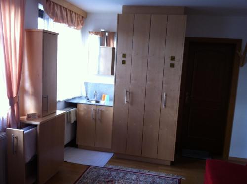 a kitchen with wooden cabinets and a sink at Gästehaus AIGMÜLLER in Bad Schallerbach