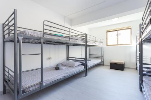 two bunk beds in a room with a window at Safari Beach guest house in Lagos
