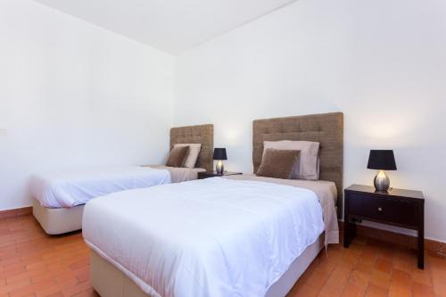 a bedroom with two beds and a night stand with two lamps at Safari Beach guest house in Lagos
