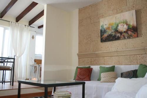 una sala de estar con un sofá blanco y una pintura en la pared en Atico Amistad, en Sevilla