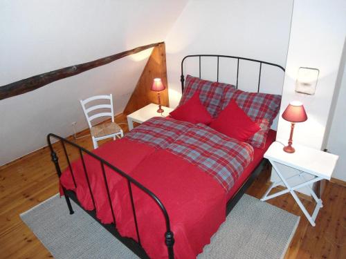 a bedroom with a red bed with red pillows at Kallmuth Cottage in Kallmuth