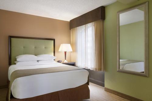 a bedroom with a large bed and a mirror at Days Inn by Wyndham Baltimore Inner Harbor in Baltimore