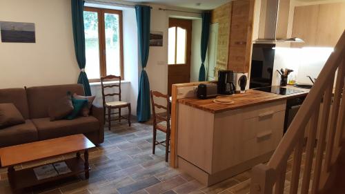 eine Küche und ein Wohnzimmer mit einem Sofa und einem Tisch in der Unterkunft Le Marite in Sartilly
