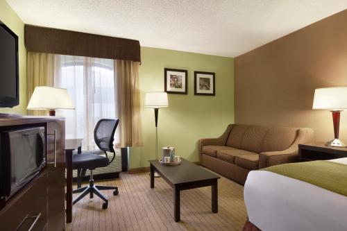 a hotel room with a bed and a couch and a television at Days Inn by Wyndham Baltimore Inner Harbor in Baltimore