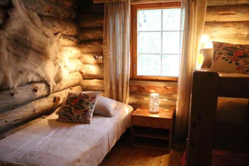 um quarto num chalé de madeira com uma cama e uma janela em Avatar Kelo Cottage em Ruka