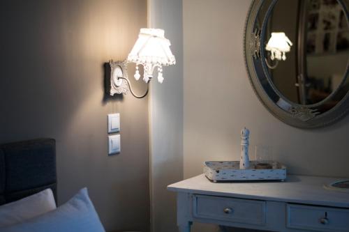 a bedroom with a mirror and a table with a lamp at Traditional house of 1898 in the heart of old town of Nafplio in Nafplio