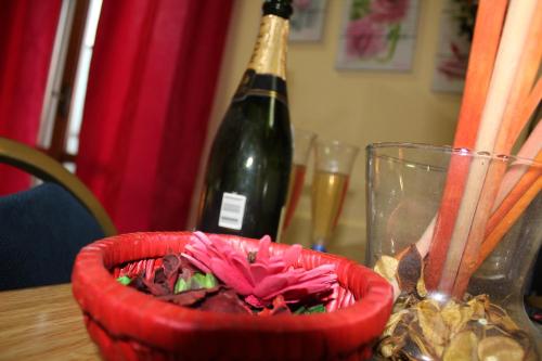 a bottle of wine and a red bowl on a table at Hotel Diana in Cassino