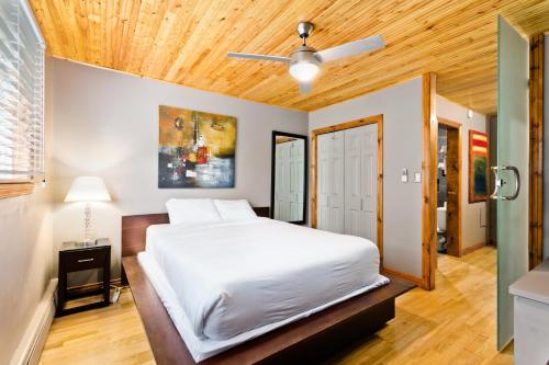 M Lofts في كالغاري: غرفة نوم بسرير ابيض وسقف خشبي