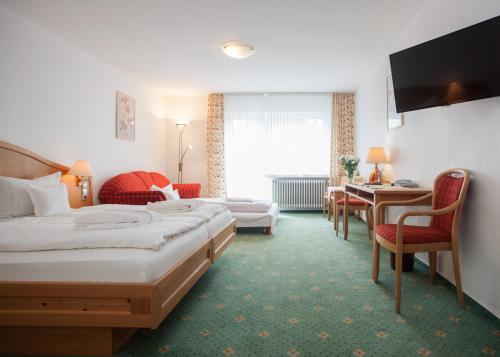 ein Hotelzimmer mit 2 Betten und einem Tisch in der Unterkunft Hotel Hessenhof in Winterberg