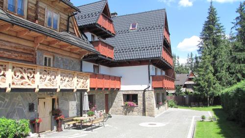 a large wooden house with a balcony at Willa U Kantora in Murzasichle