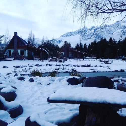 a yard covered in snow with a house in the background at Del Viejo Camino in El Bolsón