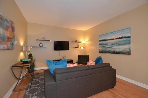 a living room with a couch and a flat screen tv at The SoMa Furnished Residences in Hamilton