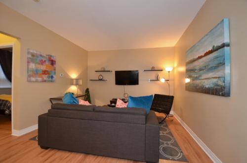 a living room with a couch and a flat screen tv at The SoMa Furnished Residences in Hamilton