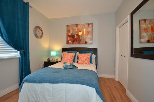 a bedroom with a bed with blue and orange pillows at The SoMa Furnished Residences in Hamilton