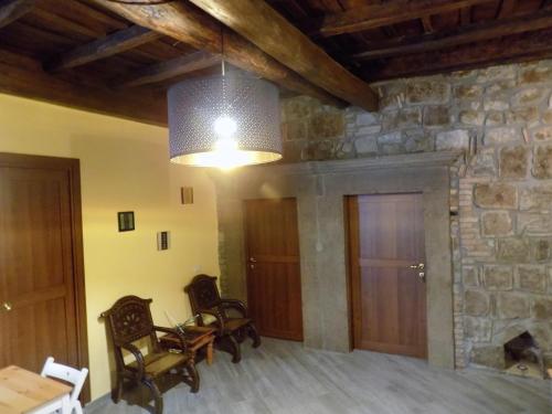 a living room with a stone wall and a chandelier at Al Cardinale in Viterbo