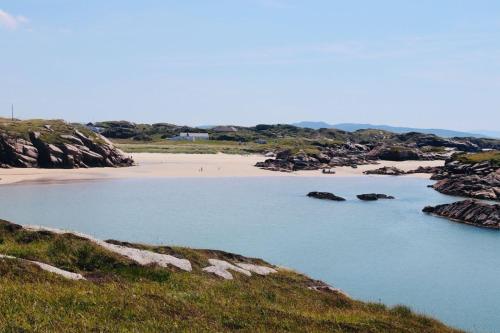 a body of water next to a beach with rocks at Hillcrest House Self Catering Apartments in Donegal