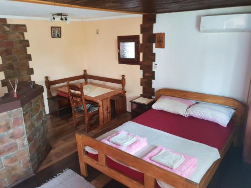 a room with a bed and a table and a fireplace at Apartmani Janković in Vrdnik